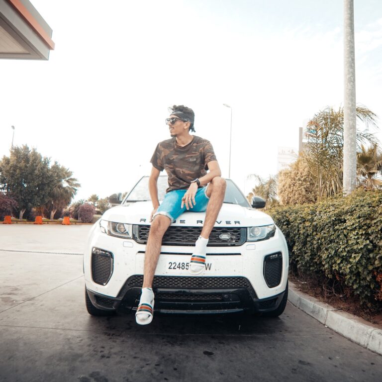Photo of Man Sitting on White Range Rover that might attract envy, jealousy or inspiration.